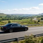 Sedan driving on scenic highway 202608040438